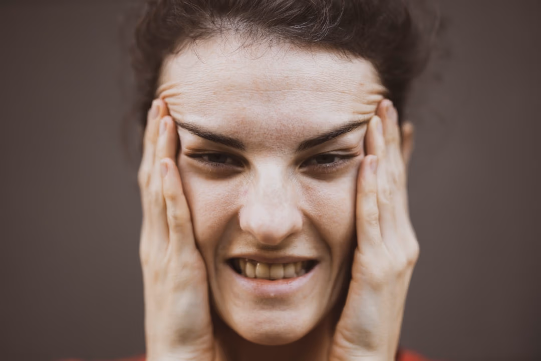 Vrouw houdt haar hand tegen haar kaak, illustratie bij osteopaat bij kaakklachten